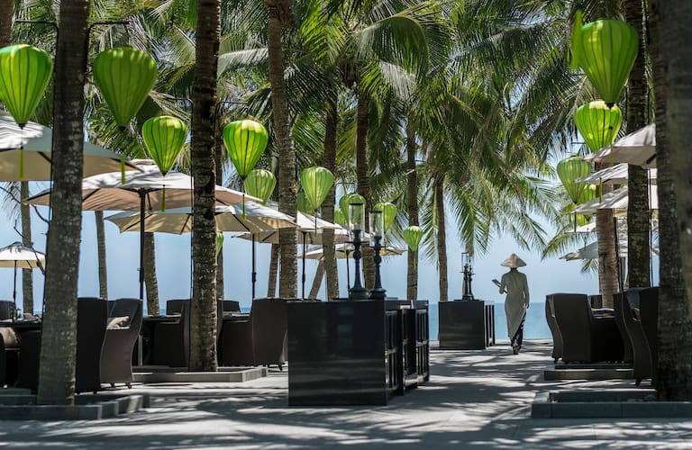 Le bar de plage du resort offre une vue sur la plage de Ha My, avec des bateaux de pêche colorés au loin. Photo / The Four Seasons