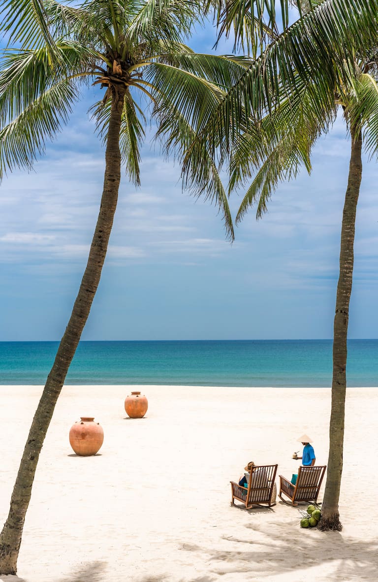 Le bar de plage du resort offre une vue sur la plage de Ha My, avec des bateaux de pêche colorés au loin. Photo / The Four Seasons