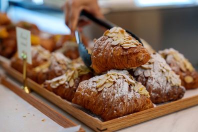 Image d'une femme asiatique prenant un croissant à la boulangerie