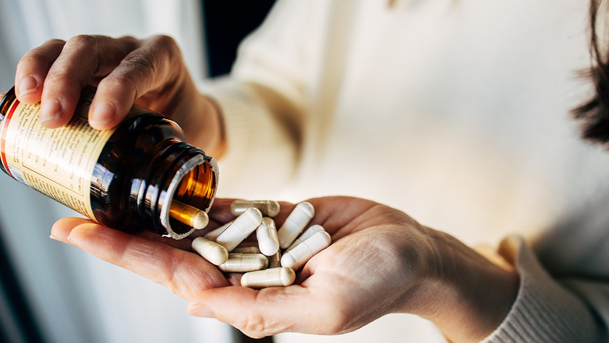 Personne versant des capsules de complément.