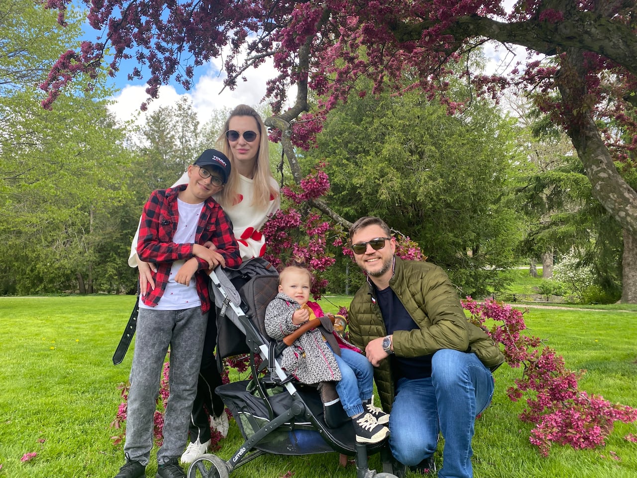 Une famille souriante devant un arbre en fleurs