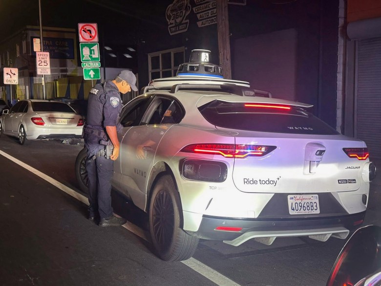 Un agent de police effectue un contrôle sur une voiture autonome Waymo.