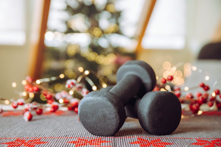 Haltères noirs avec des décorations de Noël floues en arrière-plan