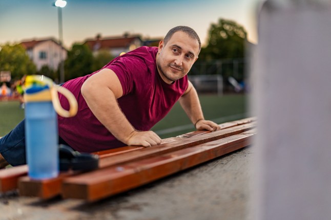 Homme en surpoids s'exerçant à l'extérieur.