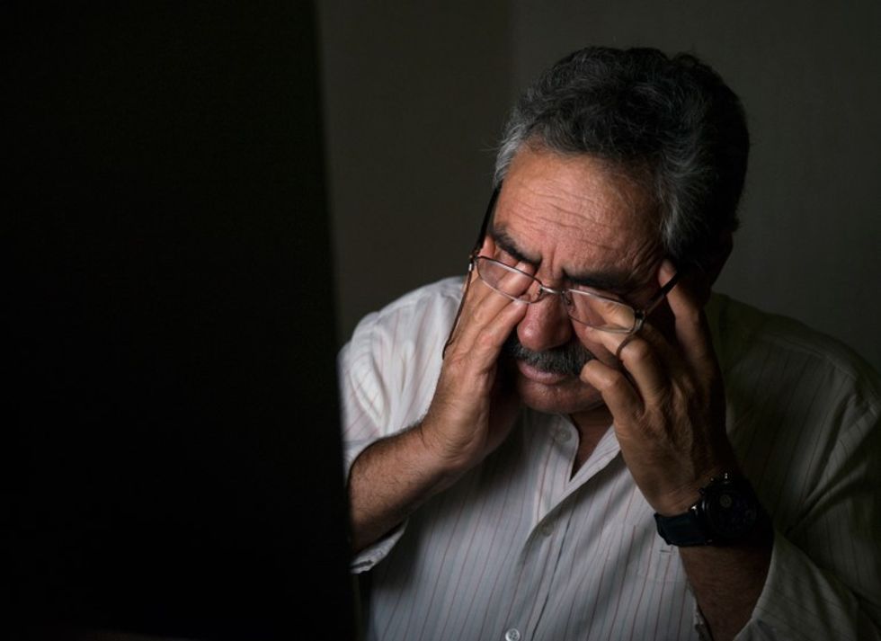 Homme âgé se frottant les yeux