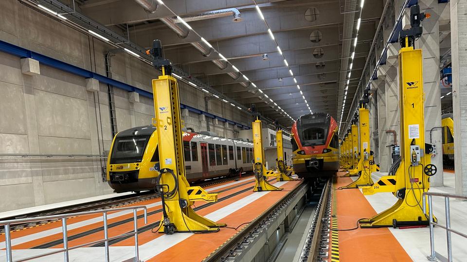 Deux trains régionaux dans une grande halle.