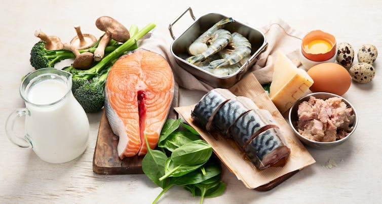 Un assortiment d'aliments riches en vitamine D, y compris saumon, sardines, jaunes d'œufs et lait.