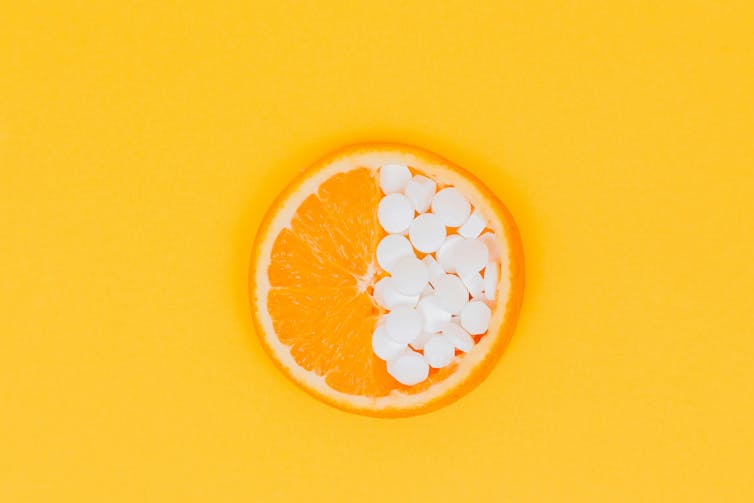Une orange et des comprimés de vitamine C