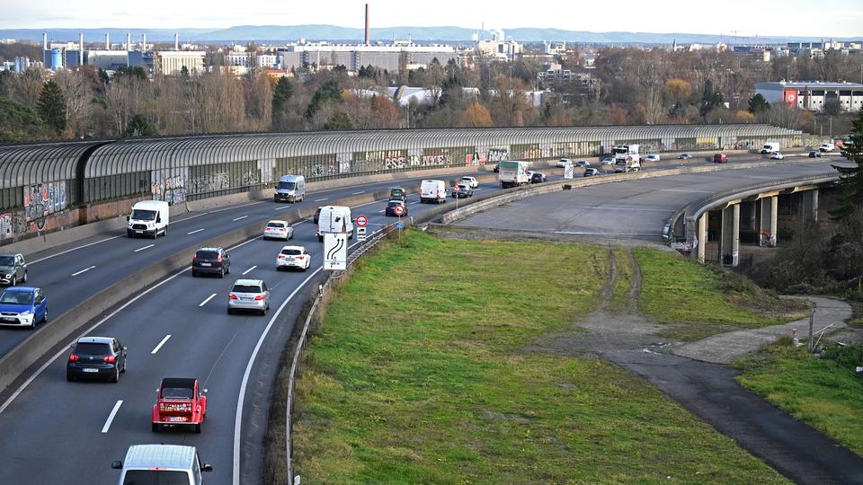 Des voitures circulent sur l'A661 près de la Seckbacher Landstraße, avec des bâtiments en arrière-plan.