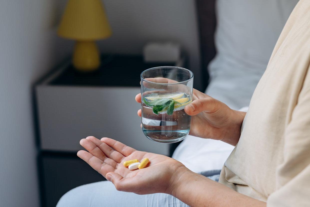 femme prenant ses vitamines et suppléments, variété de pilules et gélules