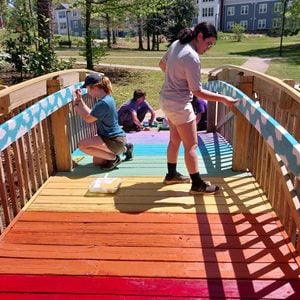 Les étudiants se rassemblent sur un pont coloré pour ajouter des détails.