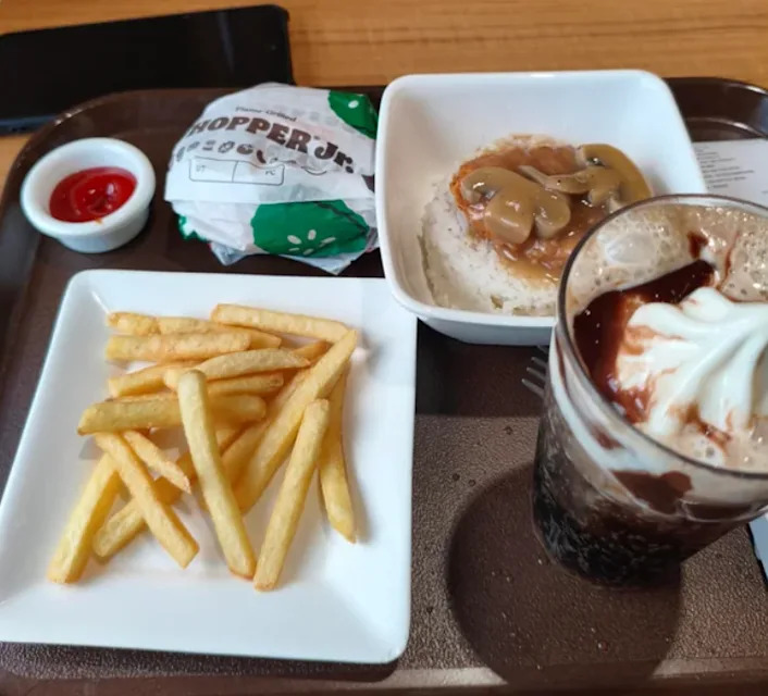 Un repas de fast-food varié avec des frites, un burger, et d'autres plats servis sur un plateau