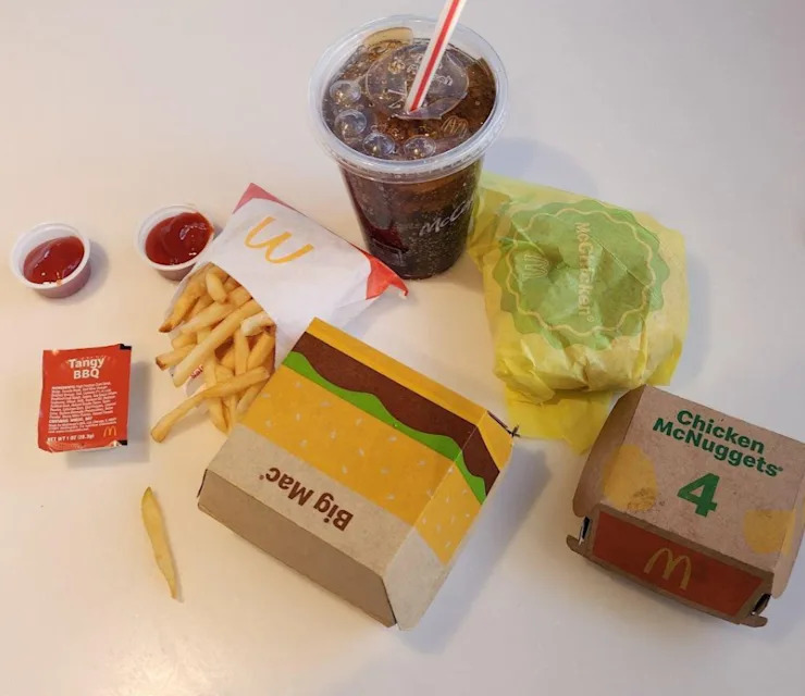 Un repas classique de fast-food avec un McChicken, des frites et des McNuggets, bien arrangés sur une table