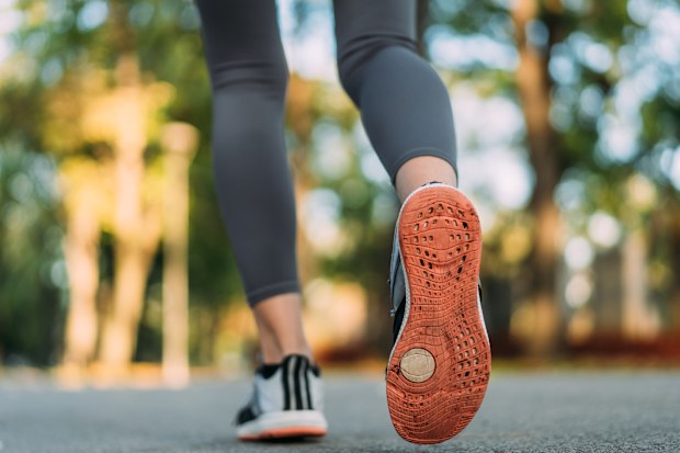 Gros plan sur des pieds féminins courant dans un parc.