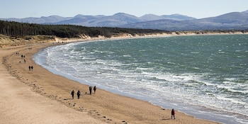 La plage de Llanddwyn allie mer ouverte, dunes naturelles et forêt côtière.