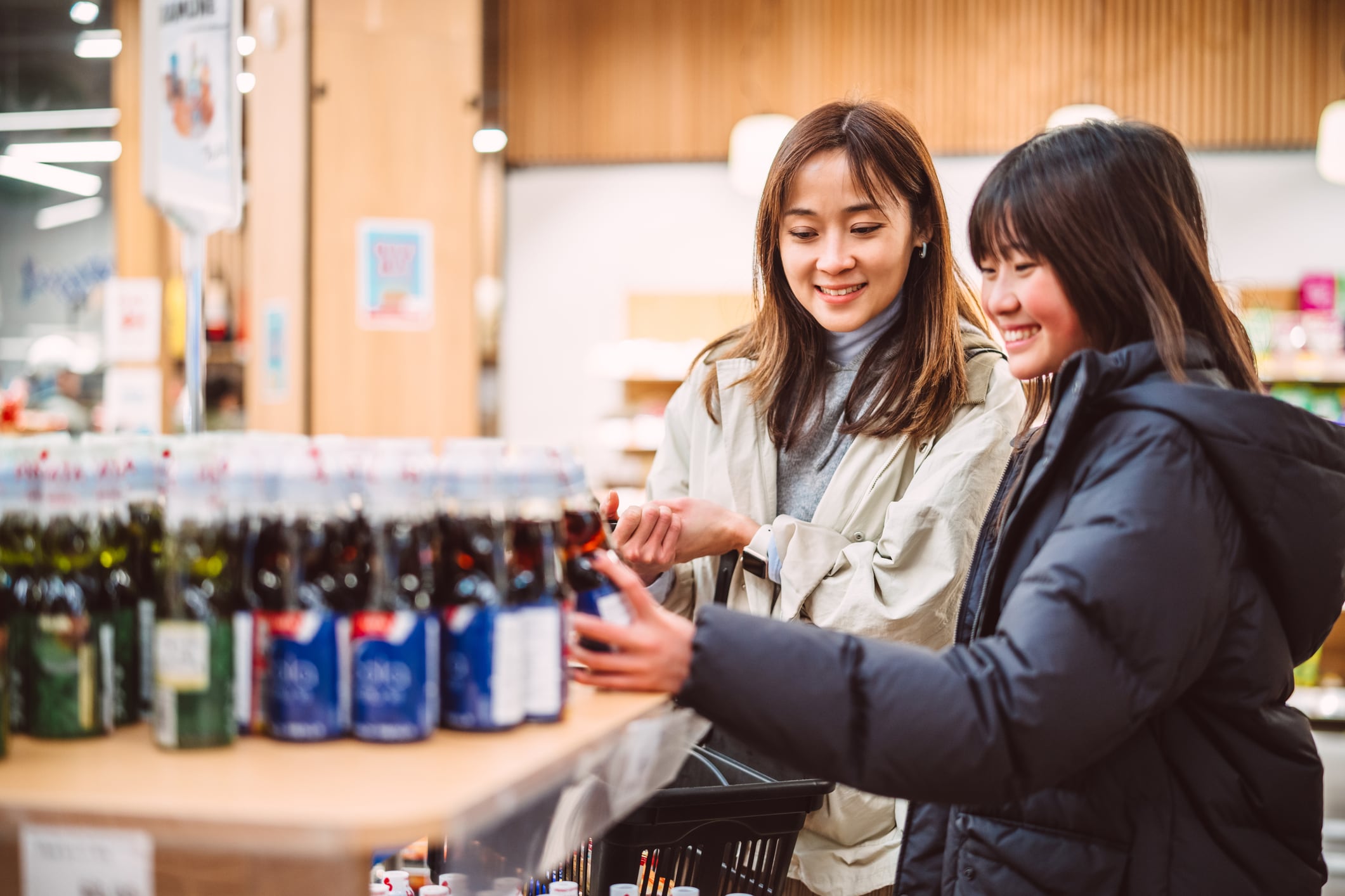 Mère et fille choisissant des boissons dans un supermarché.