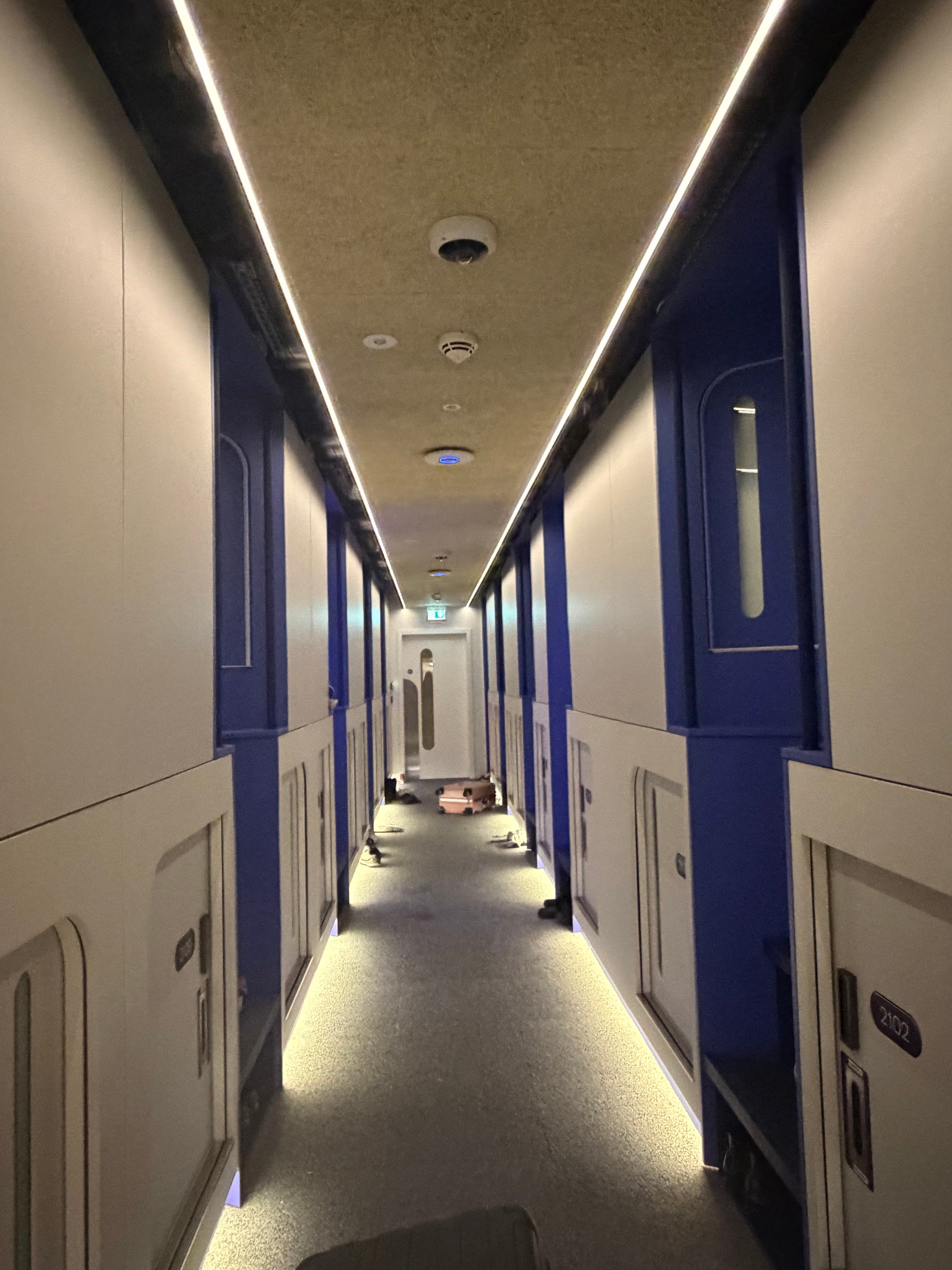 Le couloir avec les petites portes capsules chez Otherwander