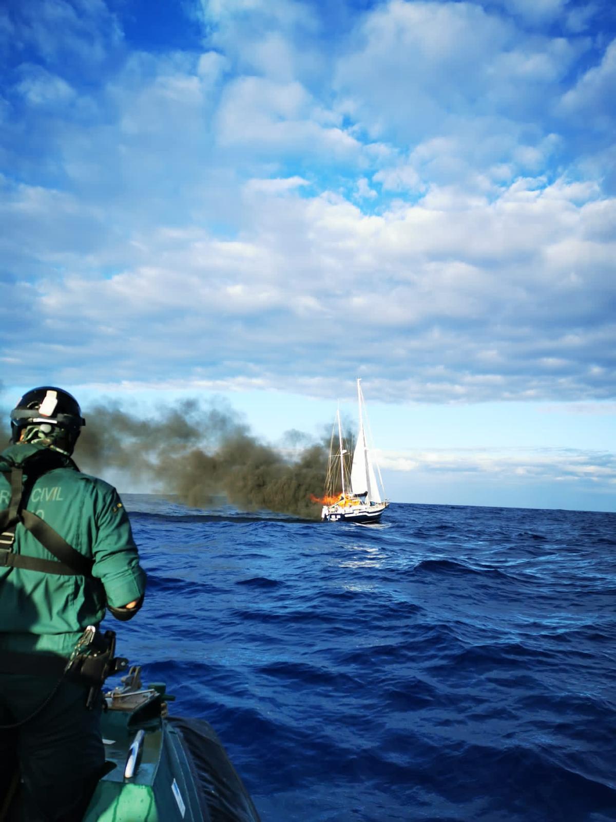 Un agent de la Guardia Civil observe le voilier Magallanes après l'incendie, dans les eaux proches des Canaries.