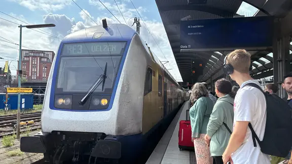 Des passagers attendent un train.