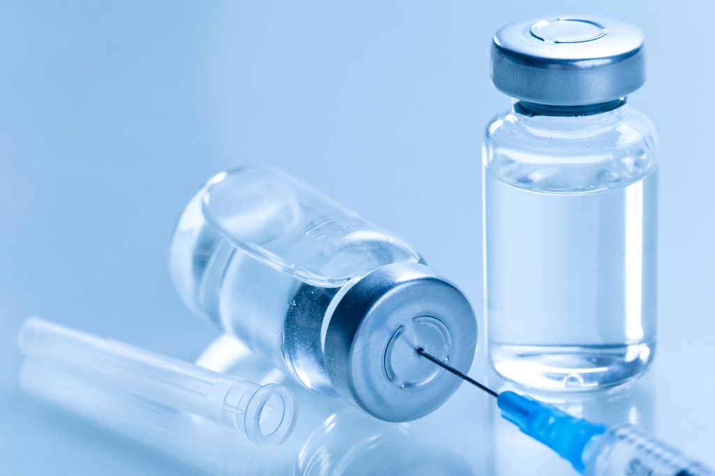 Une seringue médicale avec une aiguille dans un flacon de vaccin.