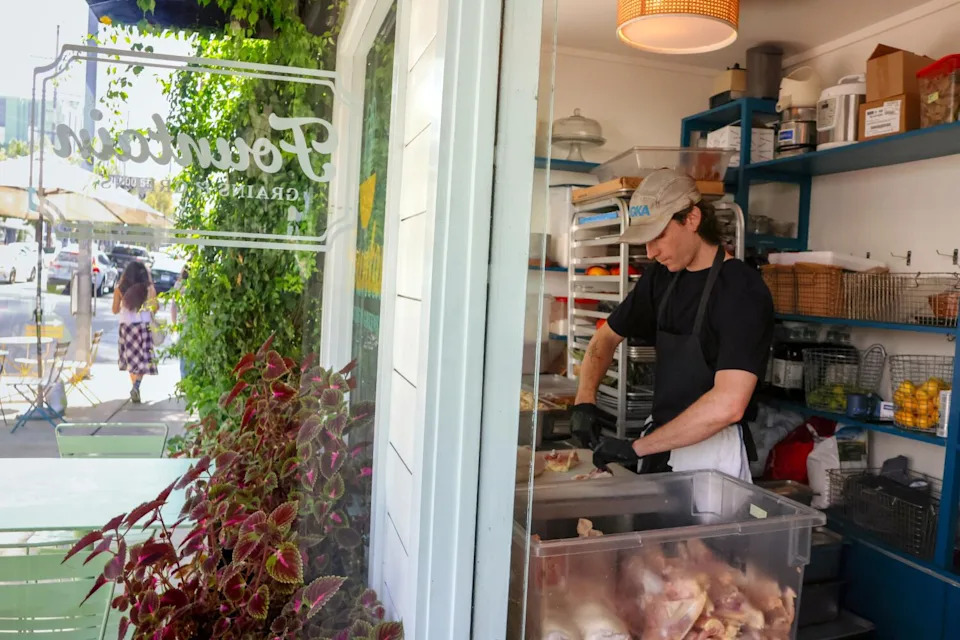 Un boucher prépare du poulet dans une cuisine de restaurant