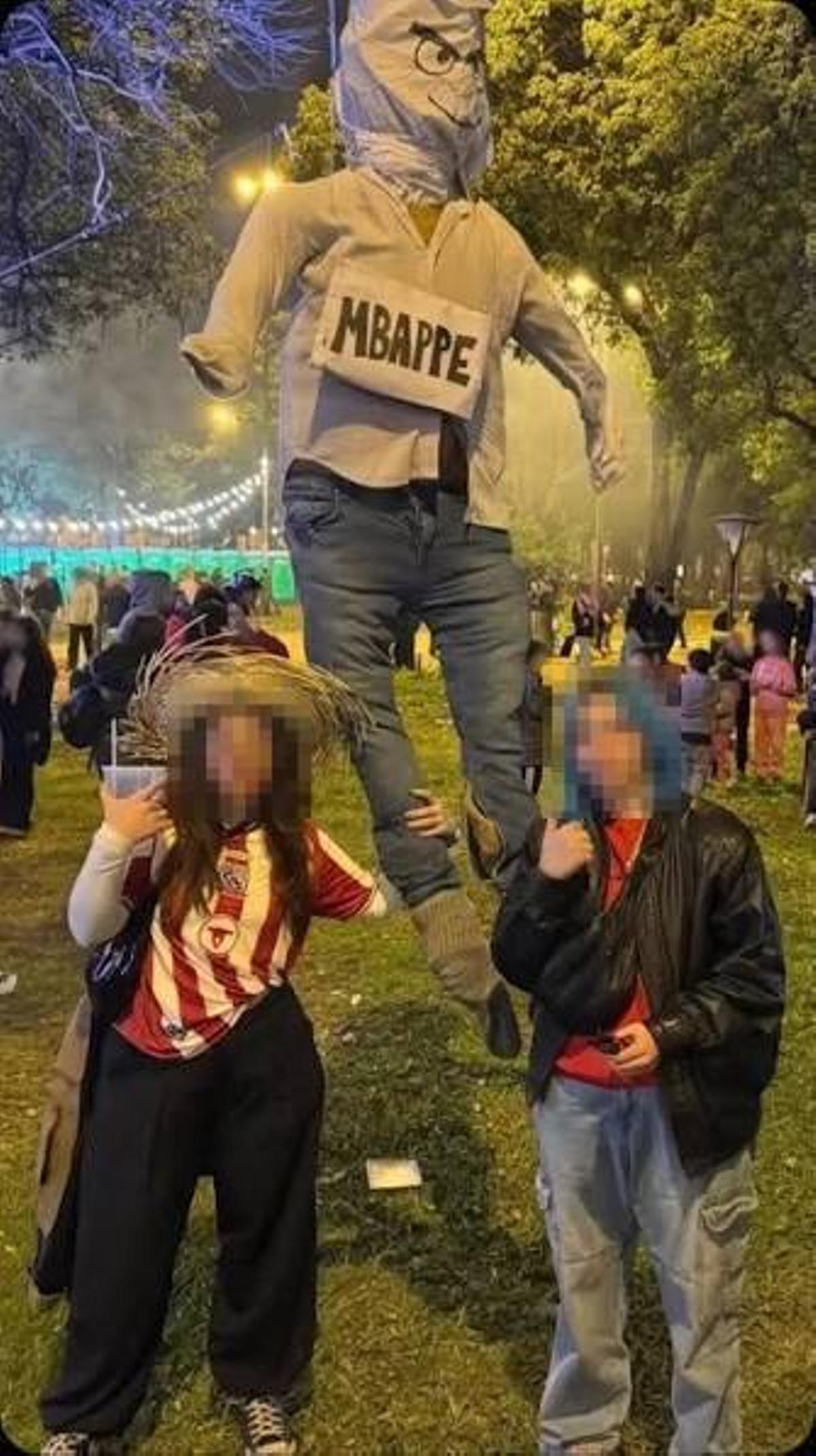 Dos hinchas paraguayos junto al muñeco de Mbappe.