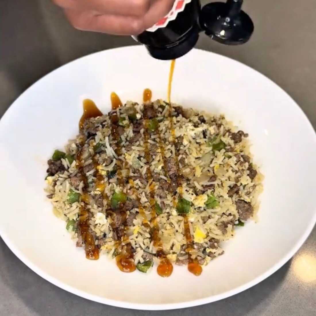 Exemple de boy kibble : un bol blanc rempli de riz, viande hachée, poivrons verts et oignons.