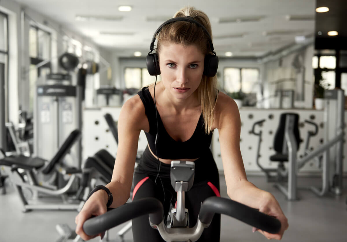 Femme faisant de l'exercice sur un vélo en écoutant de la musique