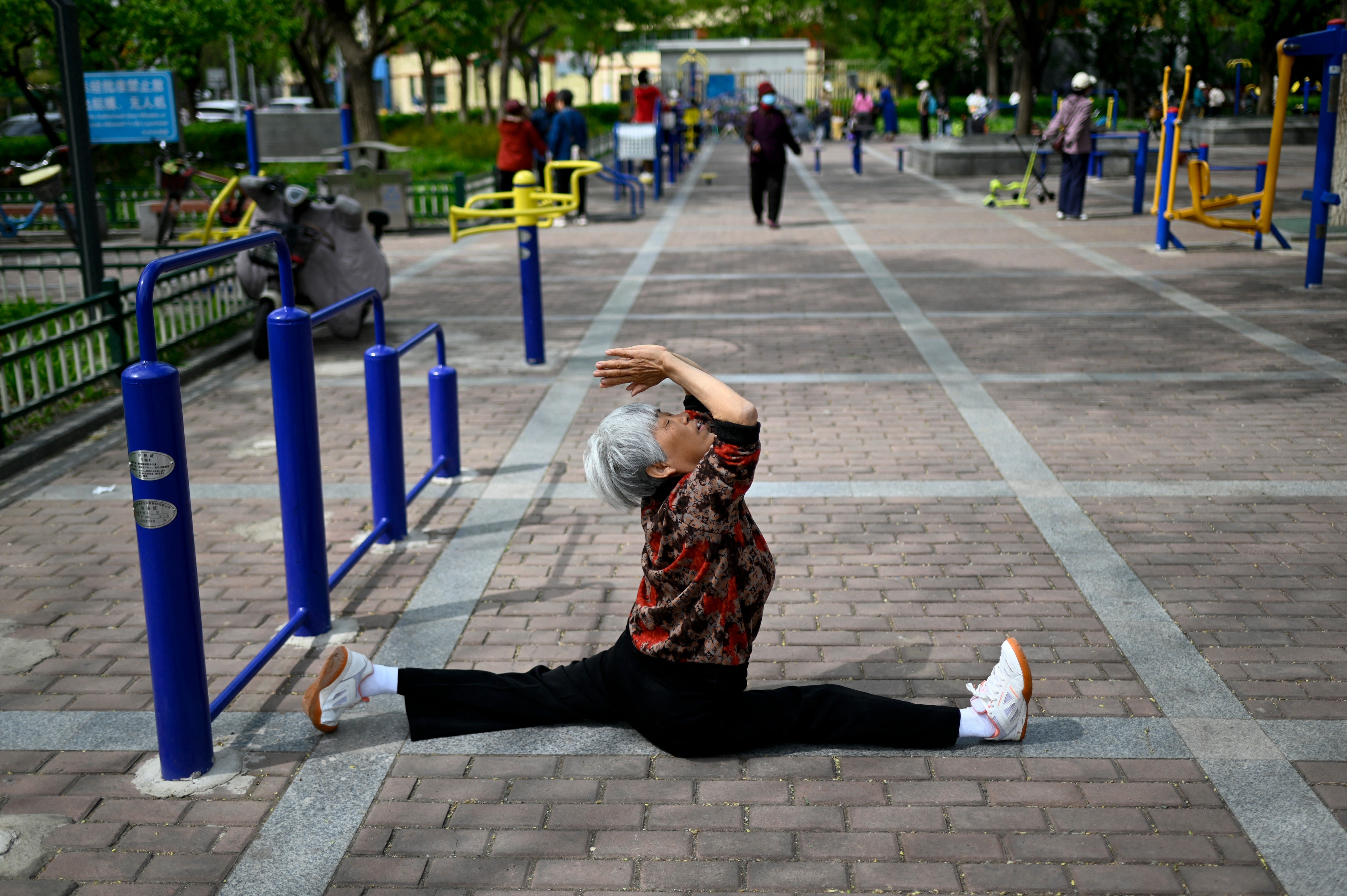 Une femme âgée s'exerce dans un jardin public à Pékin