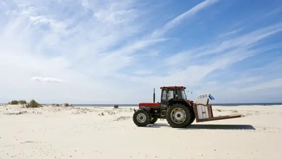 Un tracteur, un transat et beaucoup de sable : Nils Randow livre le transat numéro 584 à l'école des dunes.