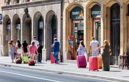 Touristes et leurs bagages se baladent sur la Via Laietana