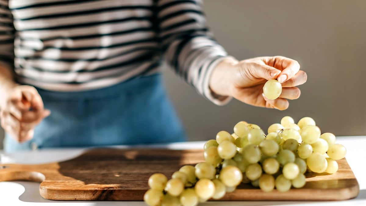 Femme mangeant des raisins